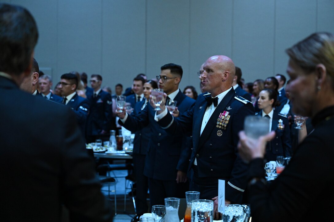 Col. Derek Oakley, center, 28th Bomb Wing commander, raises his glass alongside honorary commanders, civic leaders, commanders, chiefs, first sergeants, members of team Ellsworth and sister services during the Air Force Ball, Sept. 16, 2023, in Box Elder, South Dakota.
