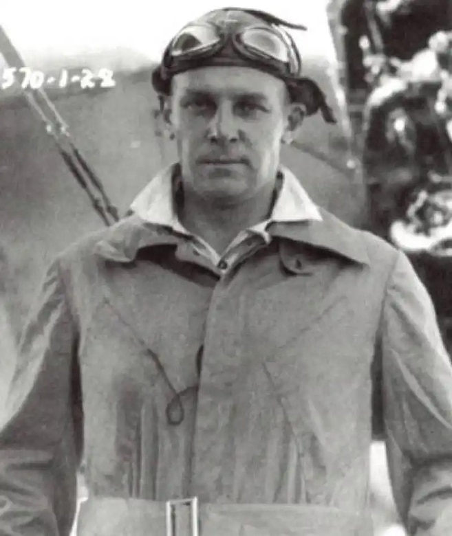 A person in flight goggles poses for a black and white photo.