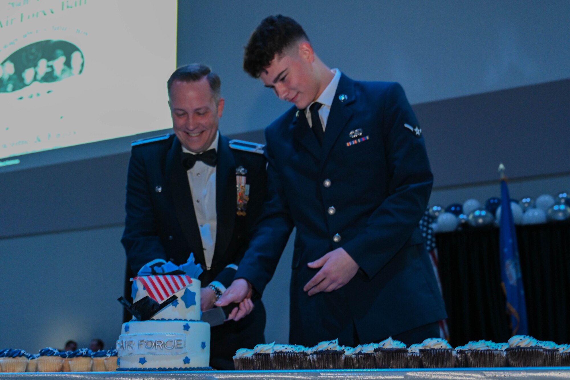 Col. Johnny West, left, 28th Maintenance Group commander, cuts the ceremonial cake with Airman Cameron Messenger, 28th Logistic Readiness traffic management technician for outbound cargo, during the Ellsworth Air Force Ball, Sept. 16, 2023, in Box Elder, South Dakota.