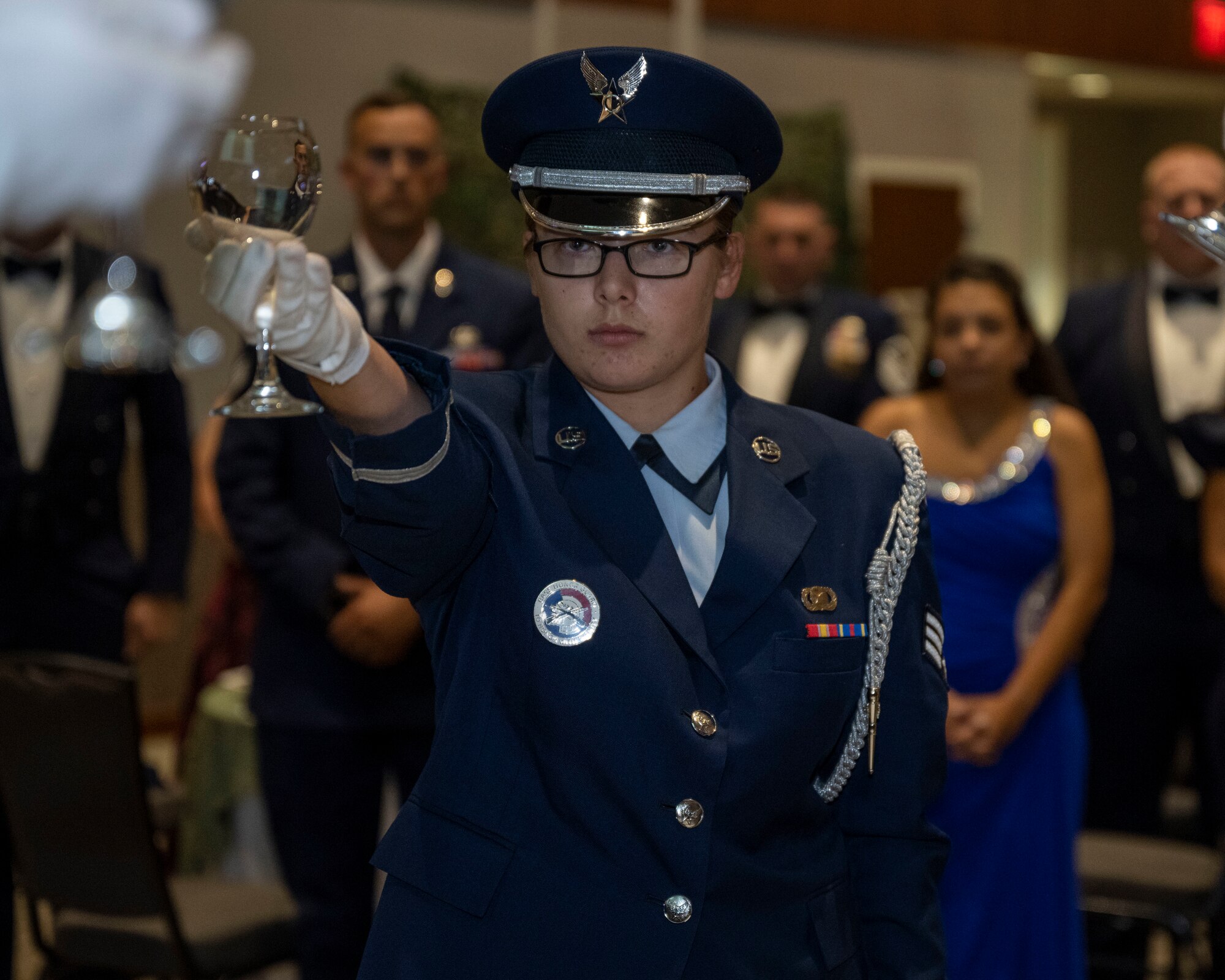 Senior Airman Sabrina Fuller, 4th Fighter Wing honor guardsmen, raises a glass as part of the prisoner of war and missing in action ceremony during the Air Force ball in Goldsboro, North Carolina, Sep. 16, 2023. The guest speaker for the event, Col. Norman McDaniel, is a Vietnam War veteran who spent six years as a prisoner of war. (U.S. Air Force photo by Senior Airman David Lynn)