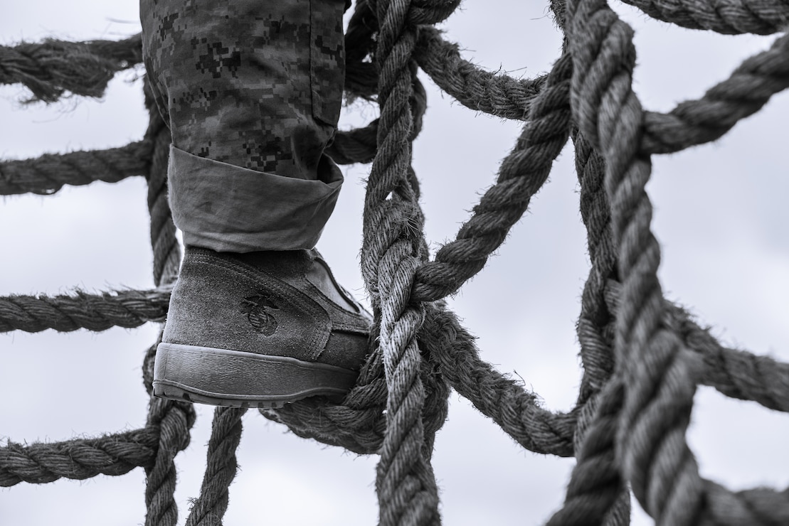 A U.S. Marine Corps recruit with Golf Company, 2nd Recruit Training Battalion, navigates a rope obstacle during a confidence course event at Marine Corps Recruit Depot San Diego, Sept. 18, 2023.