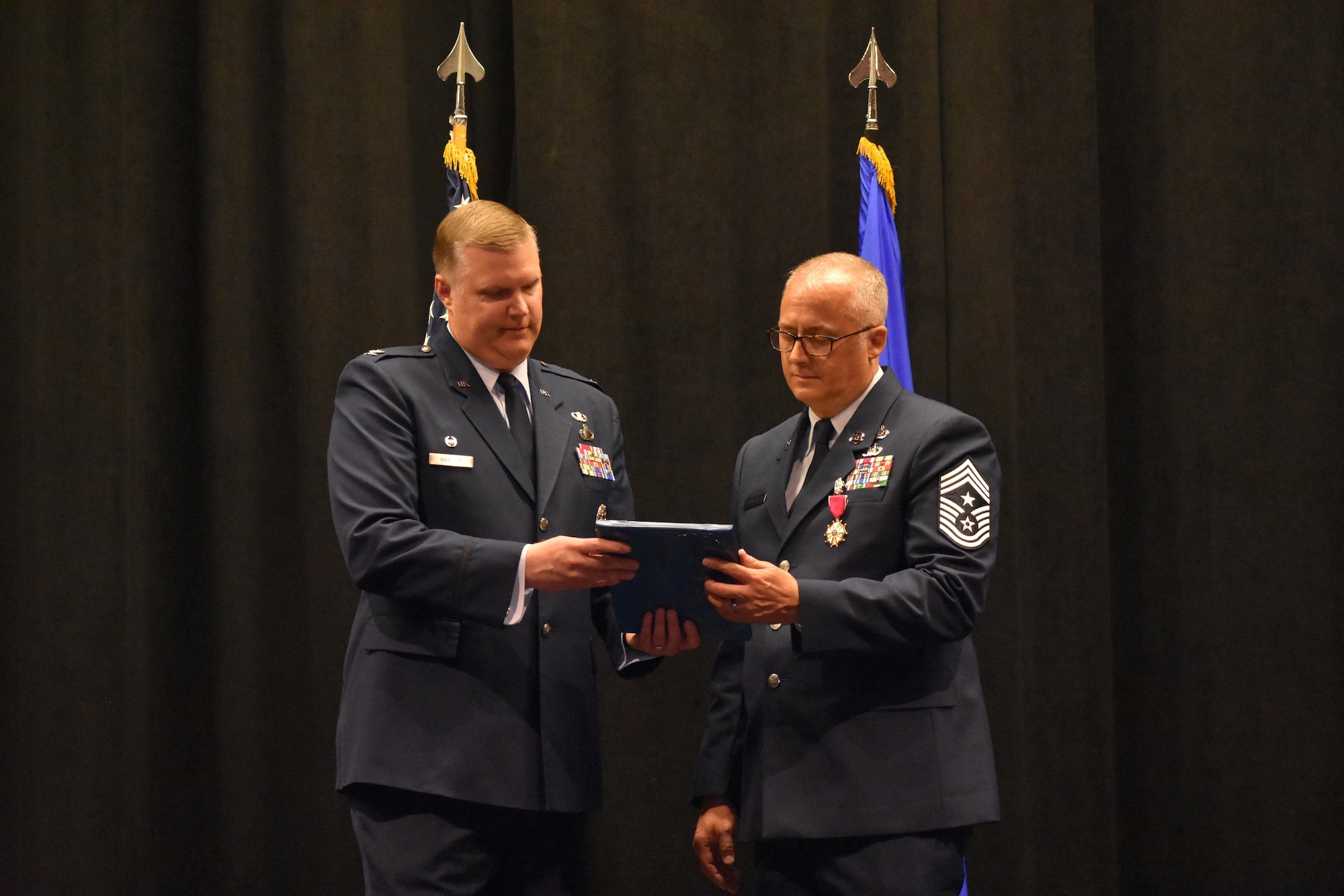 Col. Philip Warlick, left, 655th Intelligence, Surveillance and Reconnaissance Wing (ISRW) Commander, presents Chief Master Sgt. Bohdan Pywowarczuk II, 655th ISRW Command Chief, with a plaque during the chief’s retirement ceremony Sept. 9, 2023, at the National Museum of the U.S. Air Force, Dayton, Ohio. (U.S. Air Force photo/Maj. Wilson Wise)