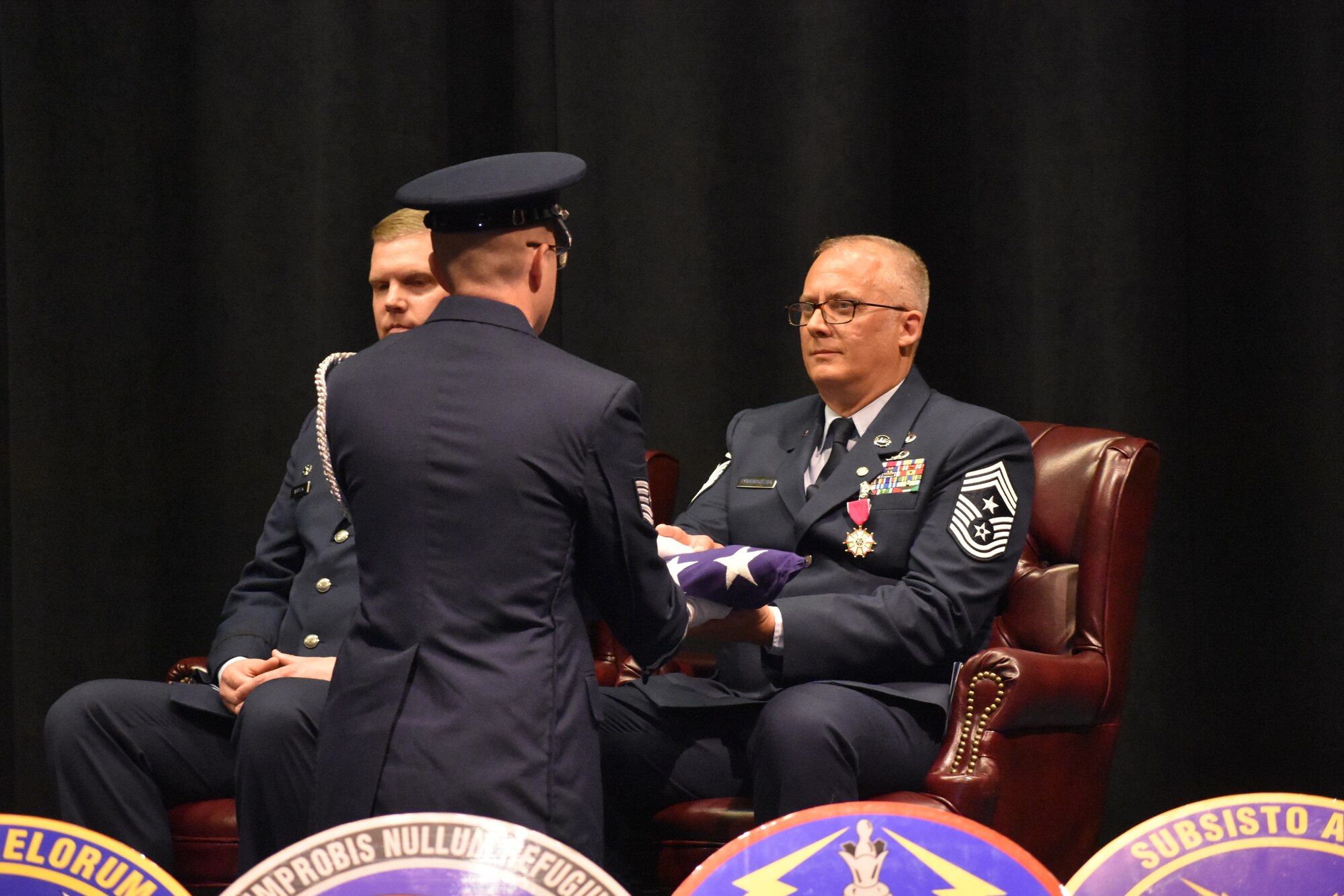 Chief Master Sgt. Bohdan Pywowarczuk II, 655th Intelligence, Surveillance and Reconnaissance Wing (ISRW) Command Chief, right, is presented with an American flag during the chief’s retirement ceremony Sept. 9, 2023, at the National Museum of the U.S. Air Force, Dayton, Ohio. (U.S. Air Force photo/Maj. Wilson Wise)