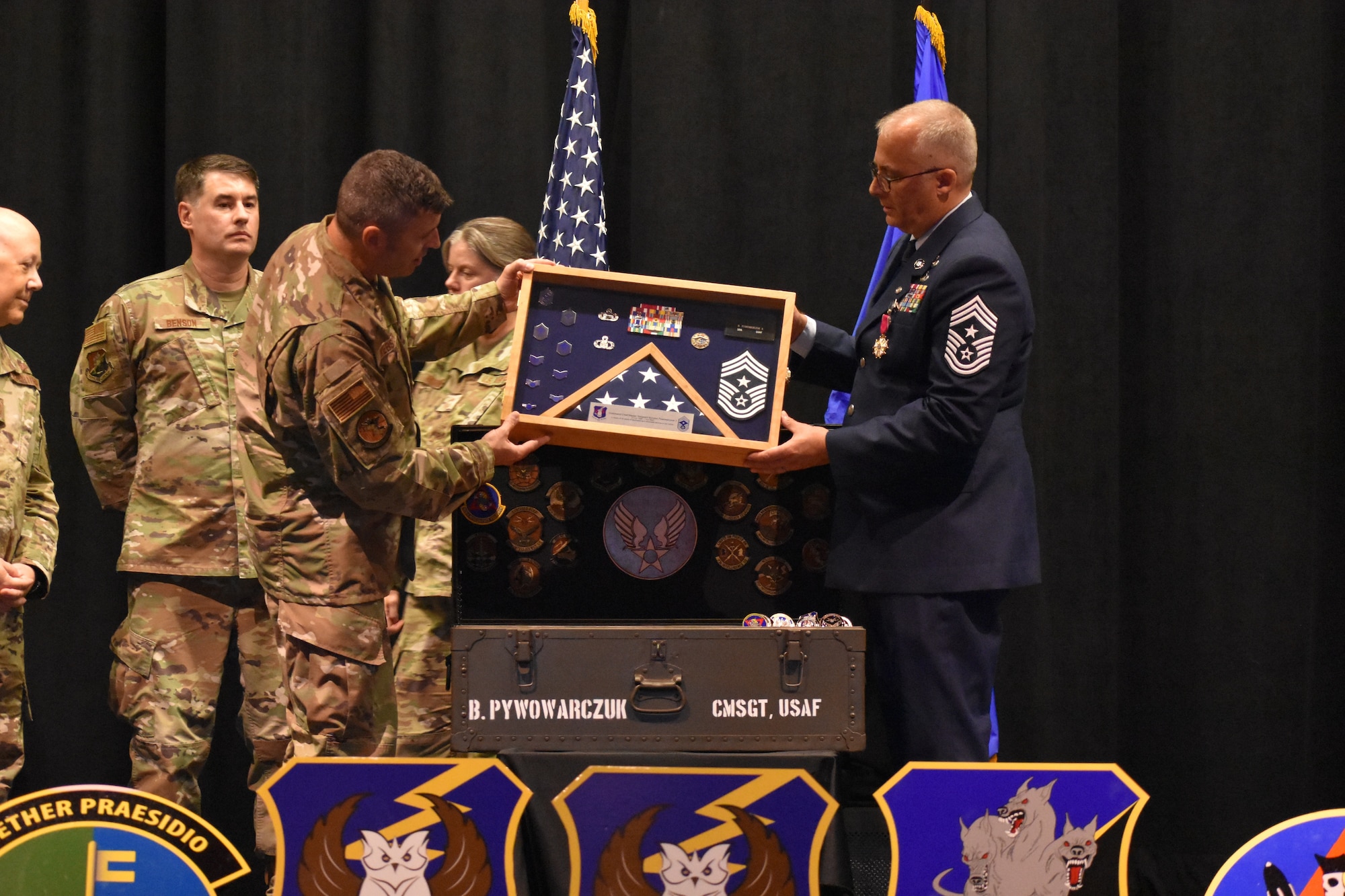 Chief Master Sgt. Bohdan Pywowarczuk II, 655th Intelligence, Surveillance and Reconnaissance Wing (ISRW) Command Chief, right, is presented with a military shadow box and other gifts from members across 655th ISRW units during the chief’s retirement ceremony Sept. 9, 2023, at the National Museum of the U.S. Air Force, Dayton, Ohio.