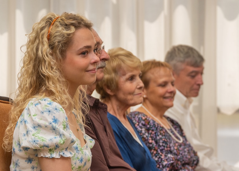 Lt. Col. (ret.) Dana Duerr’s daughter, Mikaela, and her family smile while recounting memories during Duerr’s retirement ceremony in the Gateway Club at Joint Base San Antonio-Lackland, Texas, Aug. 30, 2023. Mikaela has been caring for her mother and hopes to follow in her footsteps to be a flight nurse. (U.S. Air Force photo by Senior Airman Melody Bordeaux)