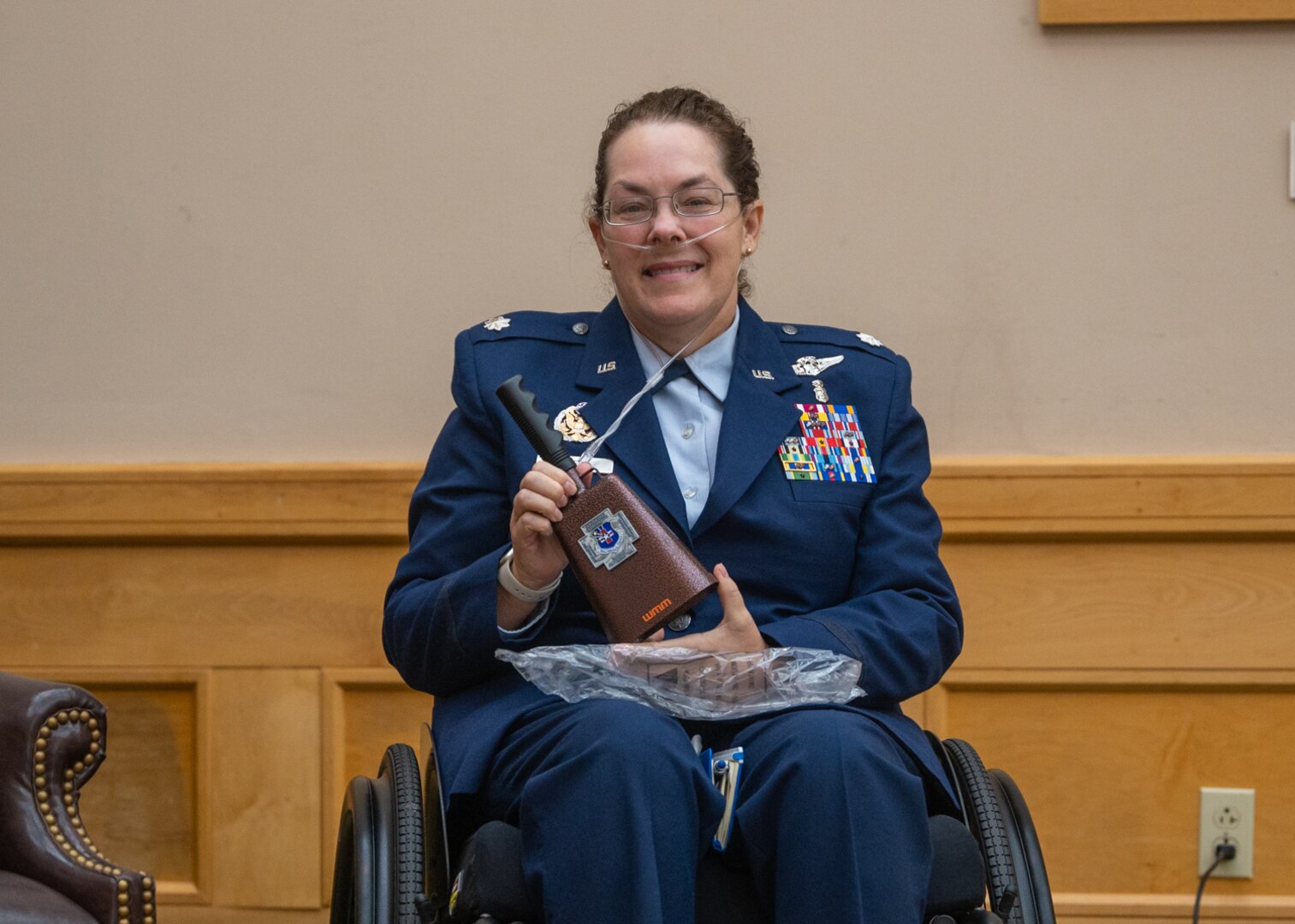 Lt. Col. (ret.) Dana Duerr, who recently served as Senior Program Manager of the Nurse Corps Education and Training Program at Air Force Medical Readiness Agency, is presented a cowbell featuring the 595th Medical Group commander’s coin during her retirement ceremony in the Gateway Club at Joint Base San Antonio-Lackland, Texas, Aug. 30, 2023. Col. John Davis, 959th MDG commander and presiding officer over the ceremony, gifted the cowbells to Duerr and Mikaela as a symbol that their care for others was instrumental in making a difference. (U.S. Air Force photo by Senior Airman Melody Bordeaux)