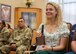 Lt. Col. (ret.) Dana Duerr’s daughter, Mikaela, is presented a cowbell featuring the 595th Medical Group commander’s coin during her mother’s retirement ceremony in the Gateway Club at Joint Base San Antonio-Lackland, Texas, Aug. 30, 2023. Col. John Davis, 959th MDG commander and presiding officer over the ceremony, gifted the cowbells to Duerr and Mikaela as a symbol that their care for others did not go unnoticed. (U.S. Air Force photo by Senior Airman Melody Bordeaux)