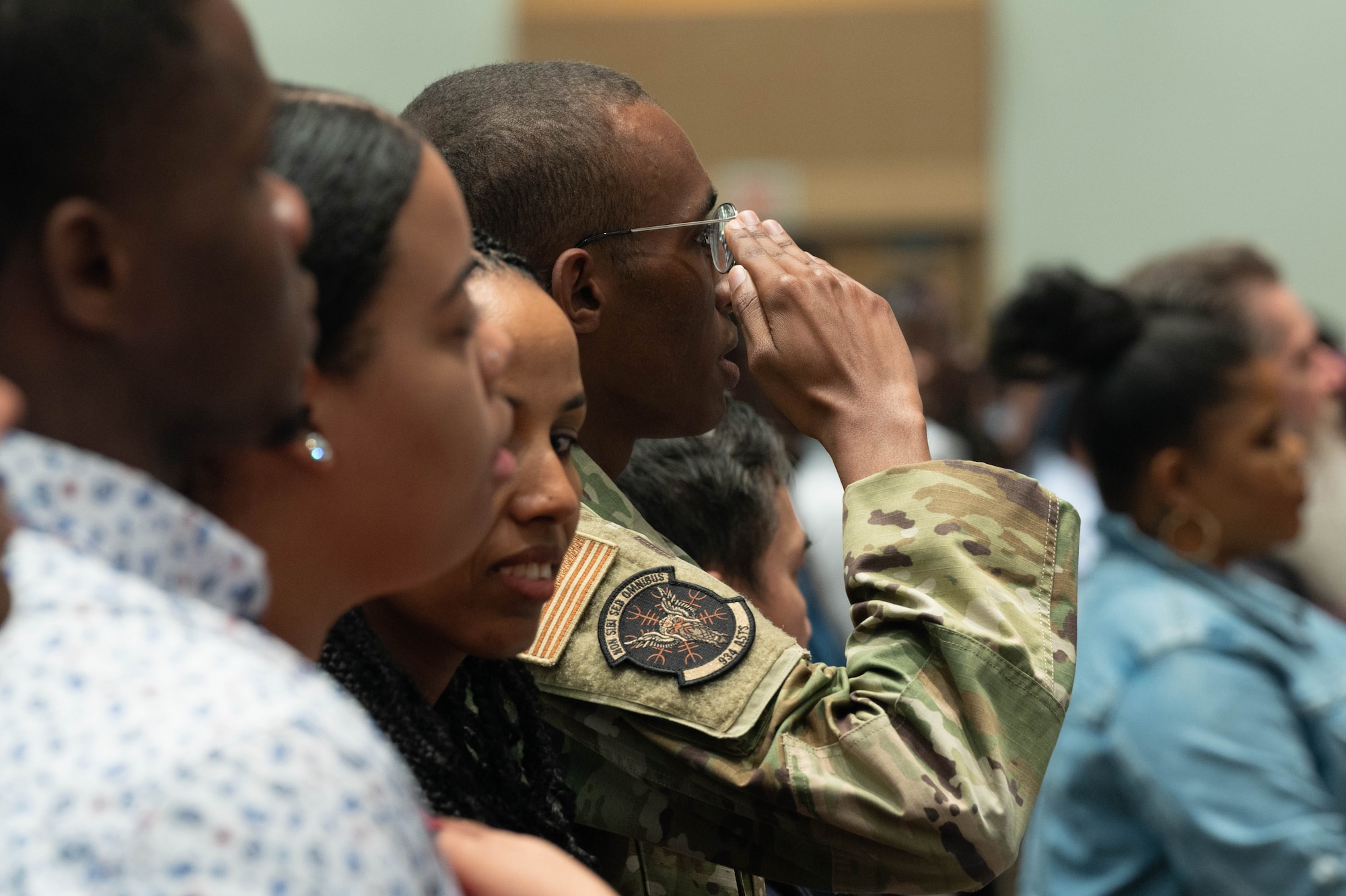 Senior Airman Mohammed Abdi, 934th Aeromedical Staging Squadron medical technician, renders a salute during the National Anthem at his naturalization ceremony at the Xcel Energy Center, St. Paul, Minn., July 14, 2023. Before Abdi became an American, he took the Oath of Enlistment in 2020 to join the Air Force Reserve and become an Airman in the 934th Airlift Wing.