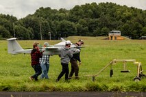 Contractors attached with the 2nd Multi-Domain Task Force, carry an aerial surveillance system after operating during exercise Arcane Thunder in Ustka, Poland Aug. 29.