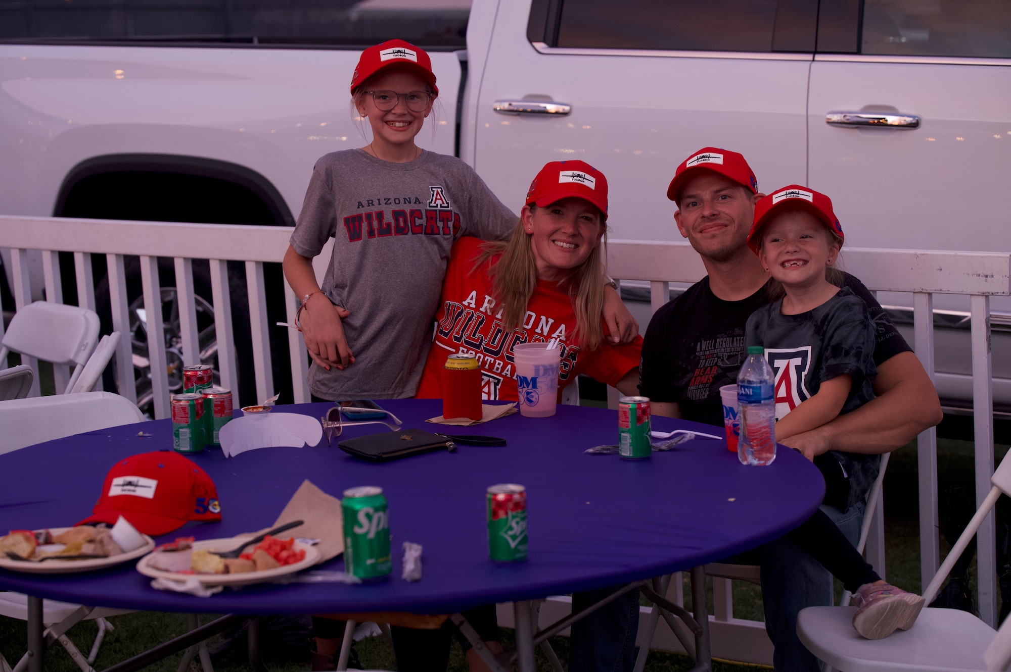 U.S. Air Force Master Sgt. Mark Doke, 355th Munitions Squadron armament maintenance section chief, sits with his family at the DM50 tailgate in Tucson, Ariz., Sept. 16, 2023. Airmen from Davis-Monthan Air Force base attended the DM50 tailgate with their families before the Wildcats game occurred in Arizona Stadium. (U.S. Air Force photo by Airman 1st Class Robert Allen Cooke III)