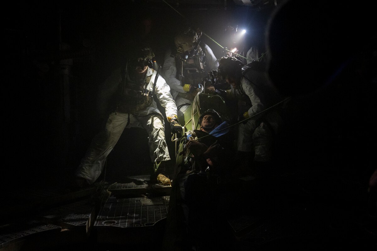 A photo of U.S. Airmen, training with the 68th Rescue Squadron, recover a simulated casualty from the lowest section of a missile silo during a Combat Leader Course training exercise at the Titan Missile Museum