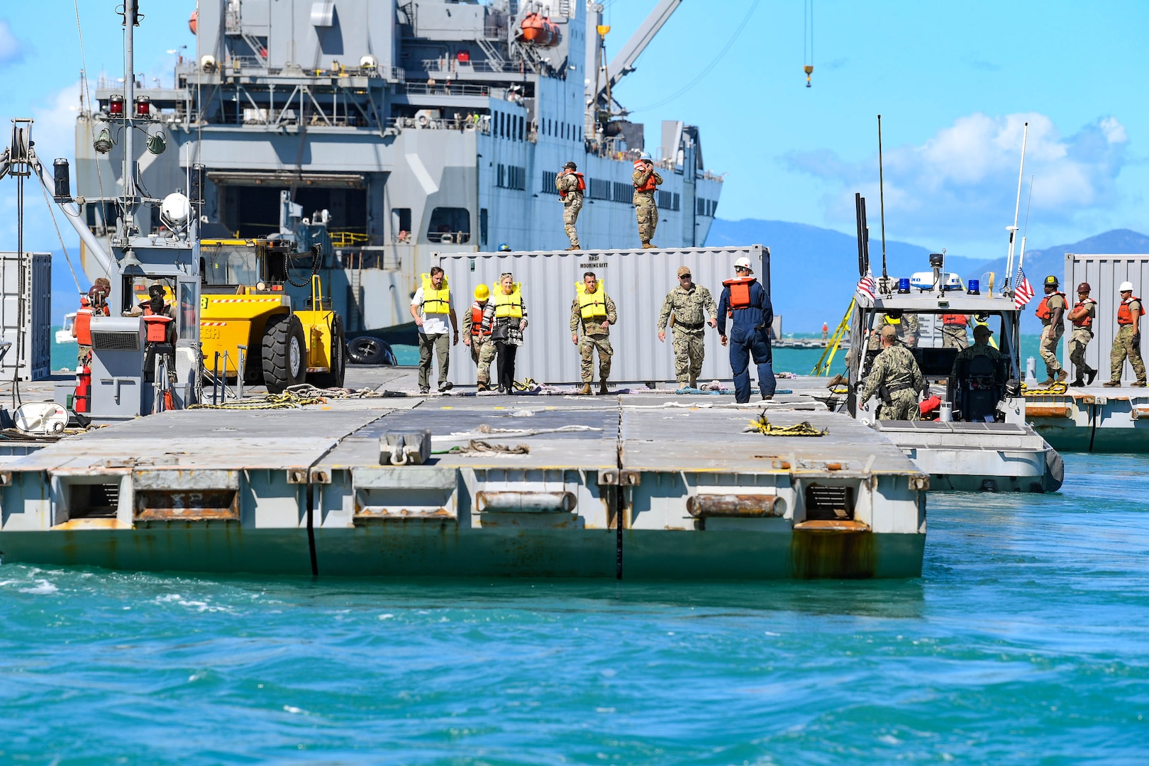 Army mariners and senior leaders stand aboard the roll on/roll off discharge facility as part of a Joint Logistics Over-the-Shore overview and brief during Talisman Sabre 2023 in Bowen, Australia, July 29, 2023. JLOTS demonstrates the critical capability of bringing vehicles and equipment to the shore in austere environments or when port facilities are unavailable. Talisman Sabre is the largest bilateral military exercise between Australia and the United States, with multinational participation, advancing a free and open Indo-Pacific by strengthening relationships and interoperability among key allies and enhancing our collective capabilities to respond to a wide array of potential security concerns. (U.S. Army photo by Sgt. Dave Resnick)