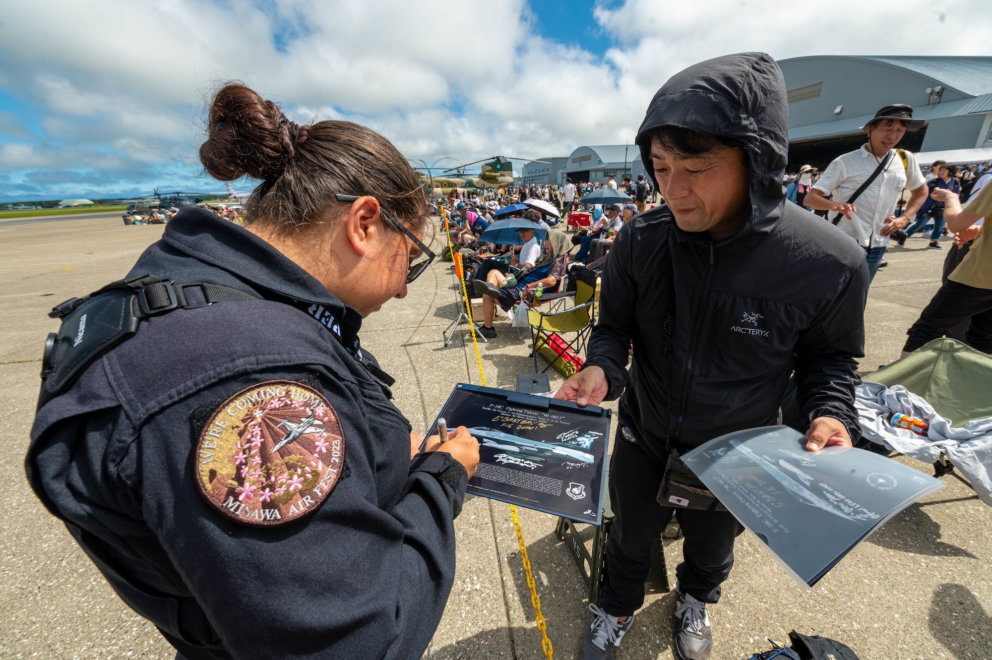 Airman signs a autograph for a fan during Misawa Air Fest 2023.