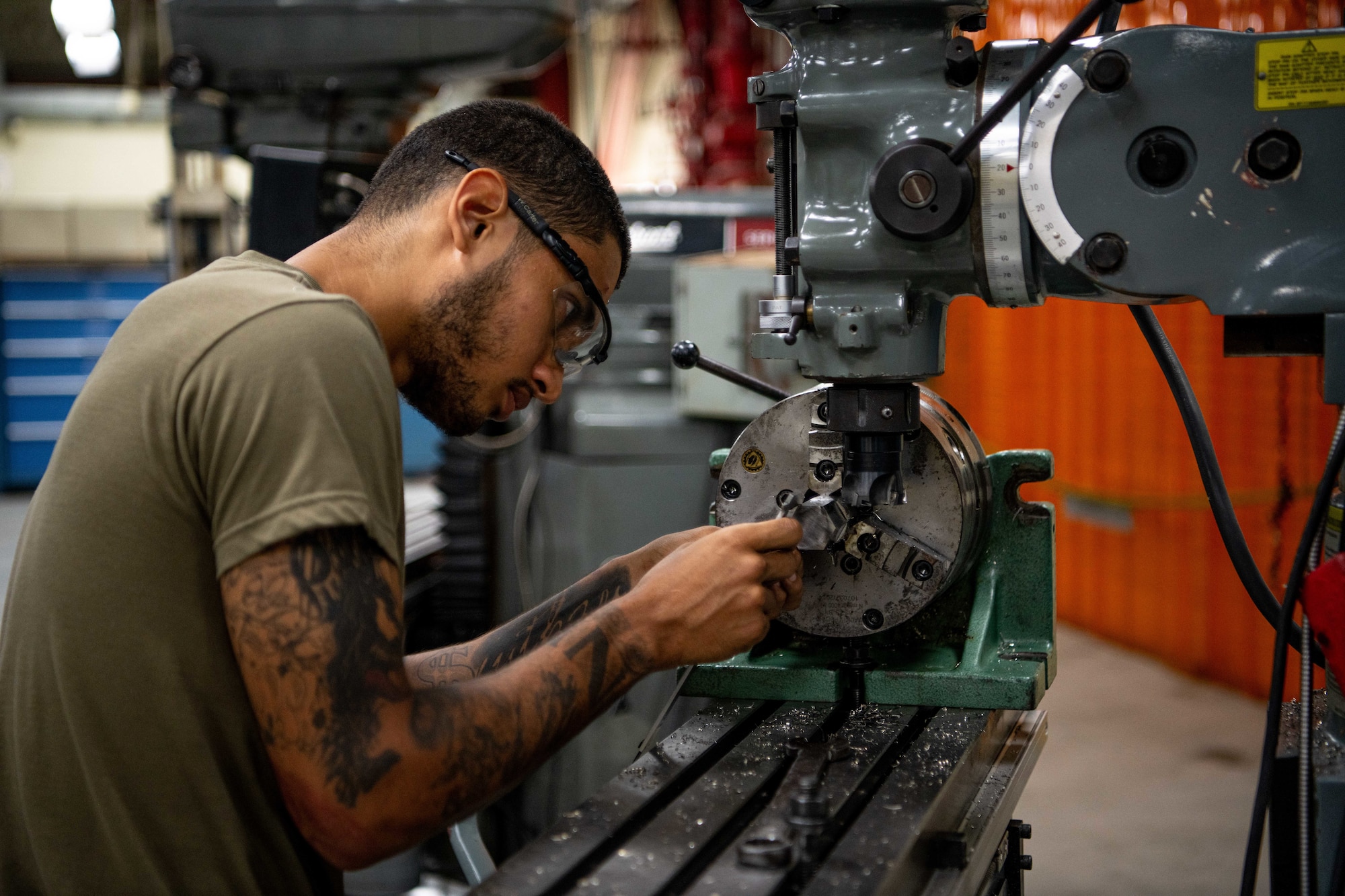 A metals technician fabricates a metal nut.
