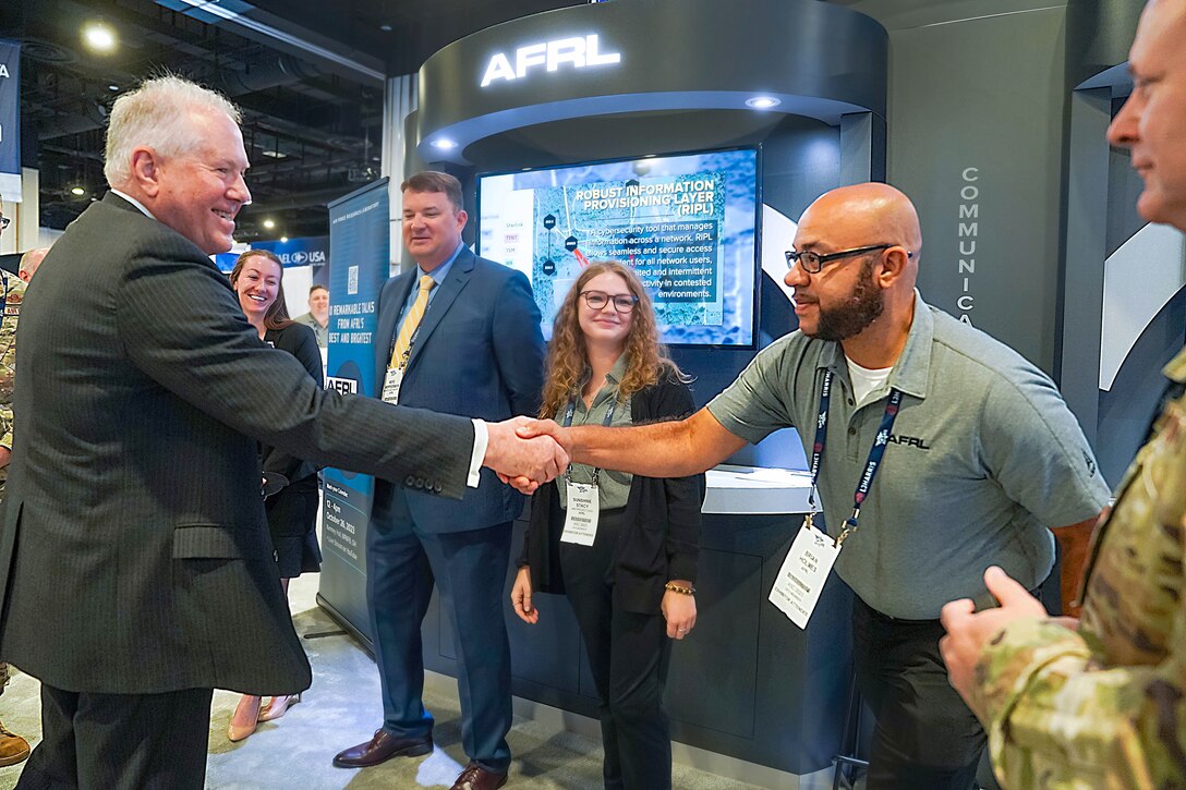 Secretary of the Air Force Frank Kendall shakes hands with Brian Holmes, AFRL program manager for Robust Information Provisioning Layer, or RIPL, a cybersecurity tool, at the Air and Space Forces Air, Space and Cyber conference at National Harbor, Maryland, Sept. 13, 2023. Secretary Kendall visited the AFRL exhibit booth and had an opportunity to learn more about RIPL. The RIPL tool manages information across a network and allows seamless and secure access to content for all network users, overcoming limited and intermittent connectivity in contested environments. (U.S. Air Force photo / Cheri Cullen)