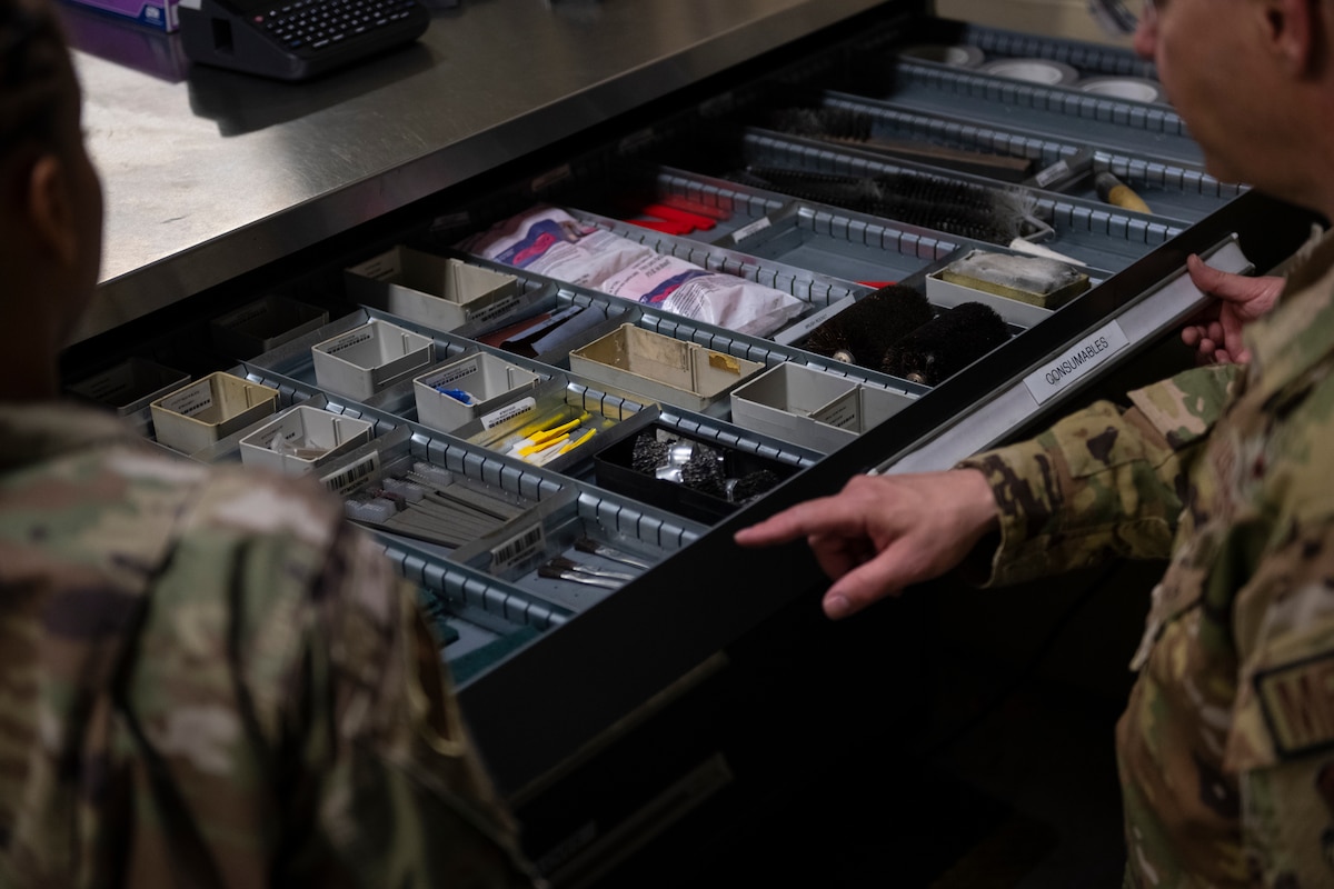 A photo of someone pointing to a drawer.