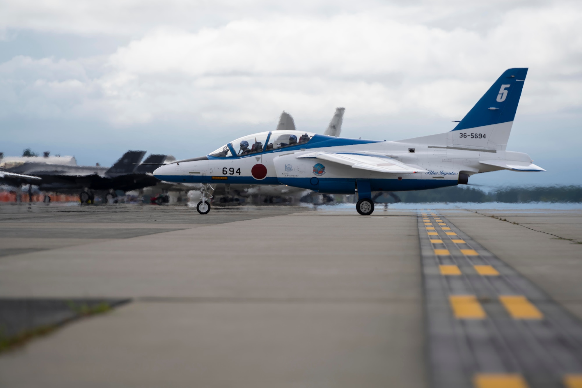 A white and blue jet on the flightline.