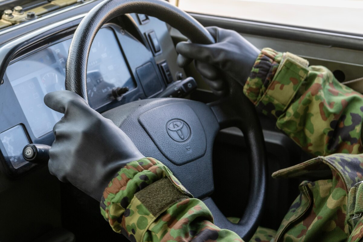 A Japan Ground Self-Defense Force Soldier assigned to the 34th Infantry Regiment grips a steering wheel while wearing mission-oriented protective posture (MOPP) gear during a training course on how to drive while in MOPP4 at Yokota Air Base, Japan, Aug. 30, 2023. JGSDF soldiers trained how to drive in a Chemical, Biological, Radiological, Nuclear and Environmental  environment with Airmen assigned to the 374th Security Forces Squadron. (U.S. Air Force photo by Yasuo Osakabe)