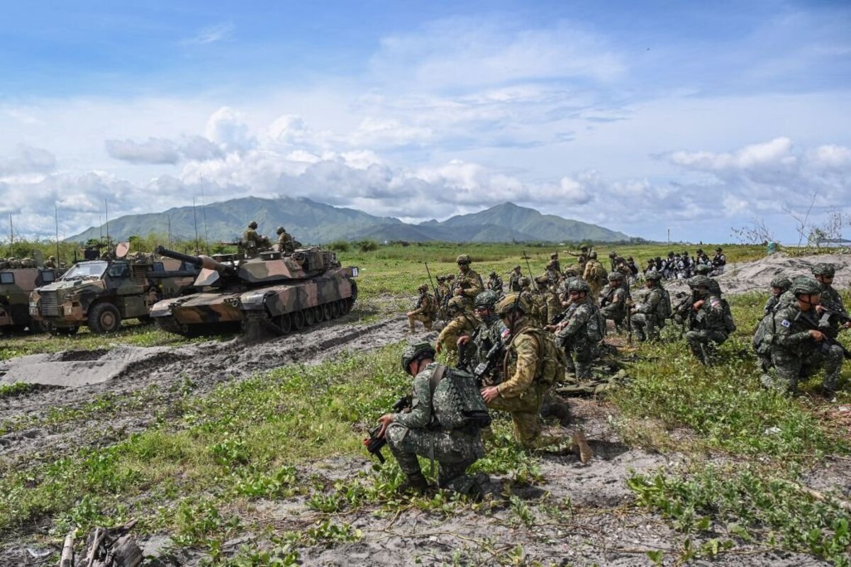 Australian and Philippine soldiers take position as an Australian A1 Abrams tank moves along a beach during a joint exercise at a naval base in San Antonio town, Zambales province on August 25, 2023