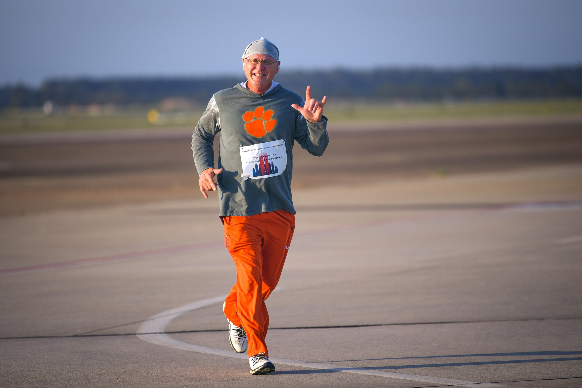 Participant smiles at the camera while jogging during the 9/11 5k.