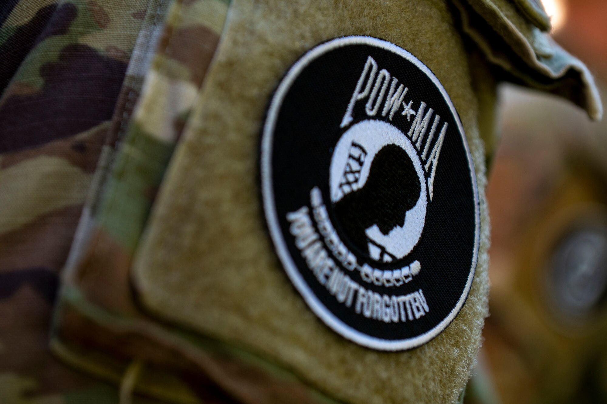 A survival, evasion, resistance and escape candidate wears a Prisoner of War/Missing in Action patch before a 24-hour ruck march at Riverfront Park in Spokane, Washington, Sept. 14, 2023. During the ruck march, Airmen from Fairchild Air Force Base kept the POW/MIA flag in constant motion to honor National POW/MIA Recognition Day. The ruck march began on Sept. 14 at the Vietnam Veterans Memorial in downtown Spokane and continued through Airway Heights before concluding at Fairchild AFB. The event culminated with a recognition ceremony on Sept. 15 to honor all American prisoners of war and those Americans still missing in action, as well as their families. Every year, the third Friday in September is recognized in the United States as National POW/MIA Recognition Day. The Department of Defense is steadfast in its commitment to finding, recovering, identifying and repatriating the remains of its heroes who are unaccounted for. (U.S. Air Force photo by Staff Sgt. Lawrence Sena)