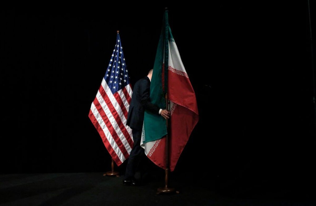 A staff member removes the Iranian flag from the stage after a group picture with foreign ministers and representatives of Unites States, Iran, China, Russia, Britain, Germany, France and the European Union during the Iran nuclear talks at Austria International Centre in Vienna, Austria on July 14, 2015