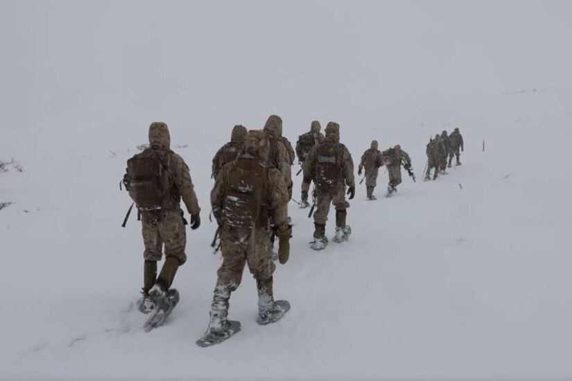 Marines walk in the snow during a training exercise