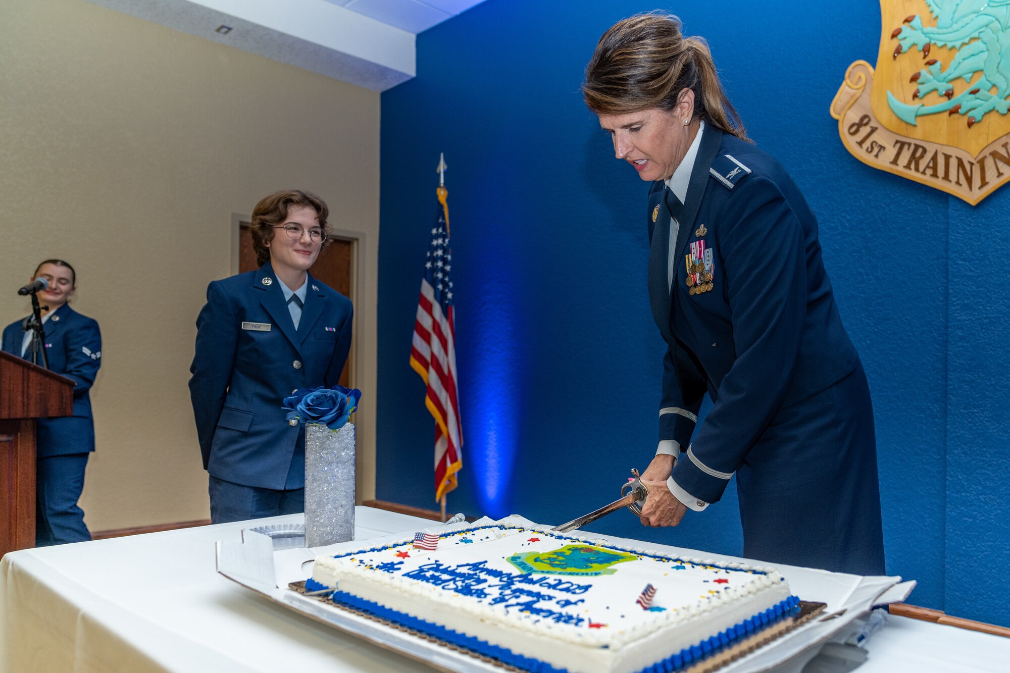 U.S. Air Force Col. Laura King, 81st Training Group commander, cuts the cake to hand to Airman Madelyn Pack, 336th Training Squadron system operations technician in training, during the Airman’s Ball at Keesler Air Force Base, Mississippi, Sept. 14, 2023.