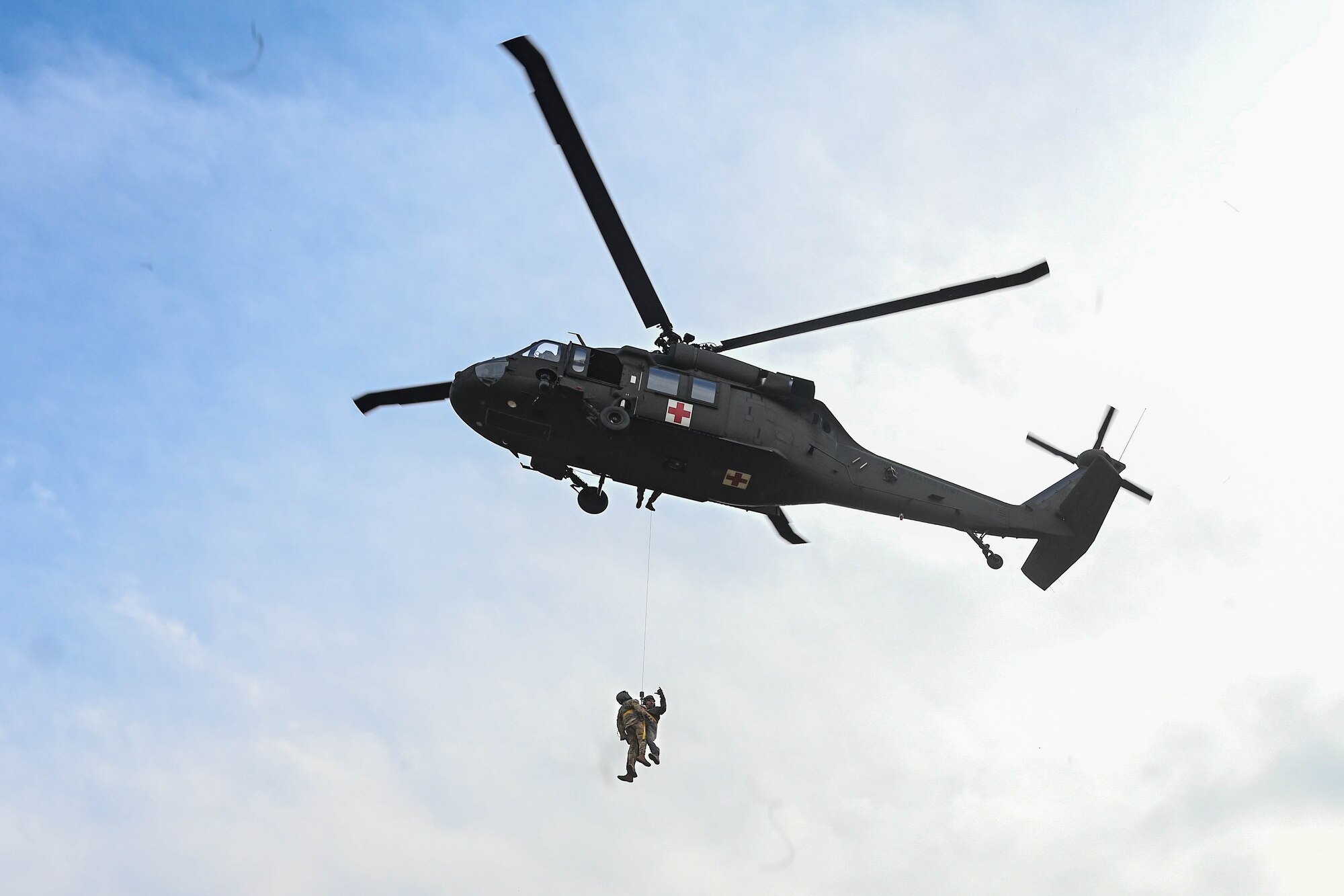 Two men are hoisted into a helicopter