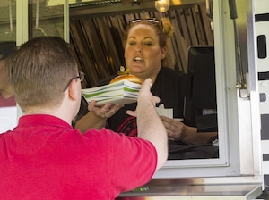 A worker from the 88th Force Support Squadron food truck “On the Run" serves lunch to a customer, Aug. 3, 2018. The 88th Air Base Wing will partner with Sinclair Community College for the next five years to help train its students how to successfully operate a food truck. (U.S. Air Force photo by R.J. Oriez)