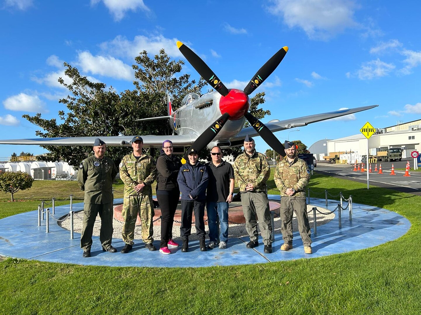 Group photo in front of airplane