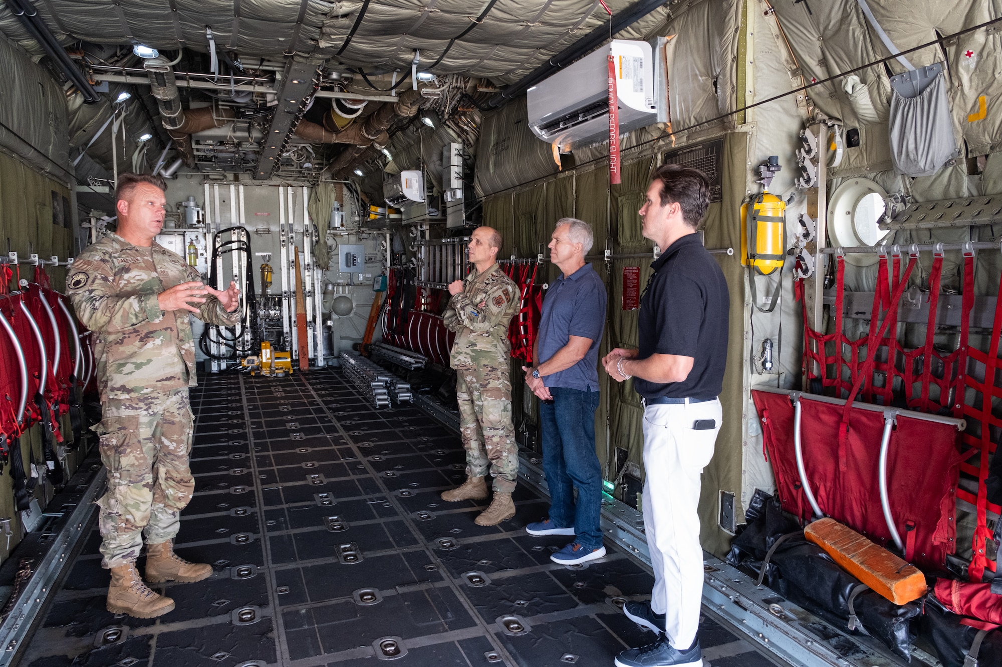 Civic leaders receive a briefing in the back of a static C-130 Hercules