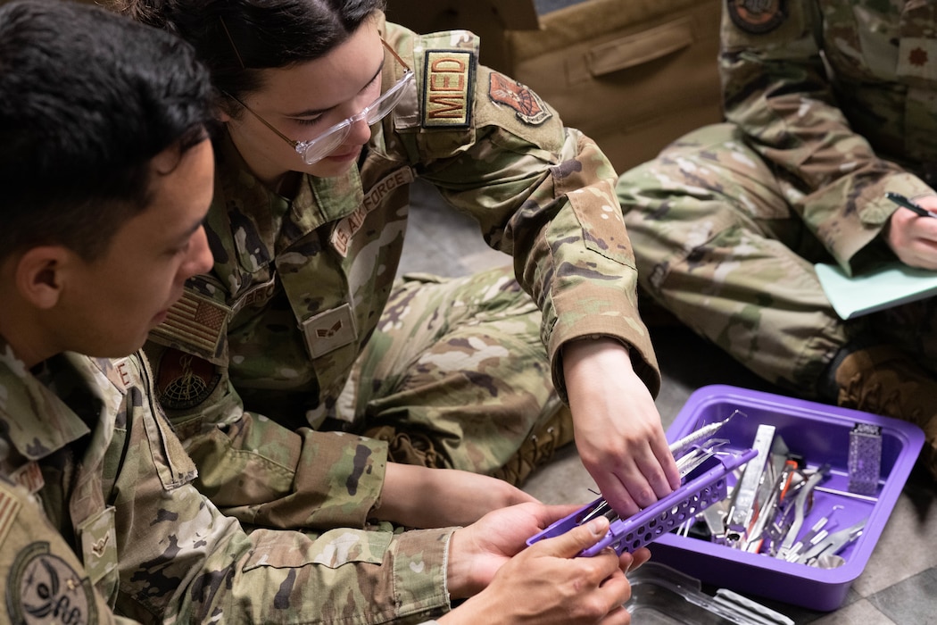 Image of two Airmen looking through equipment.