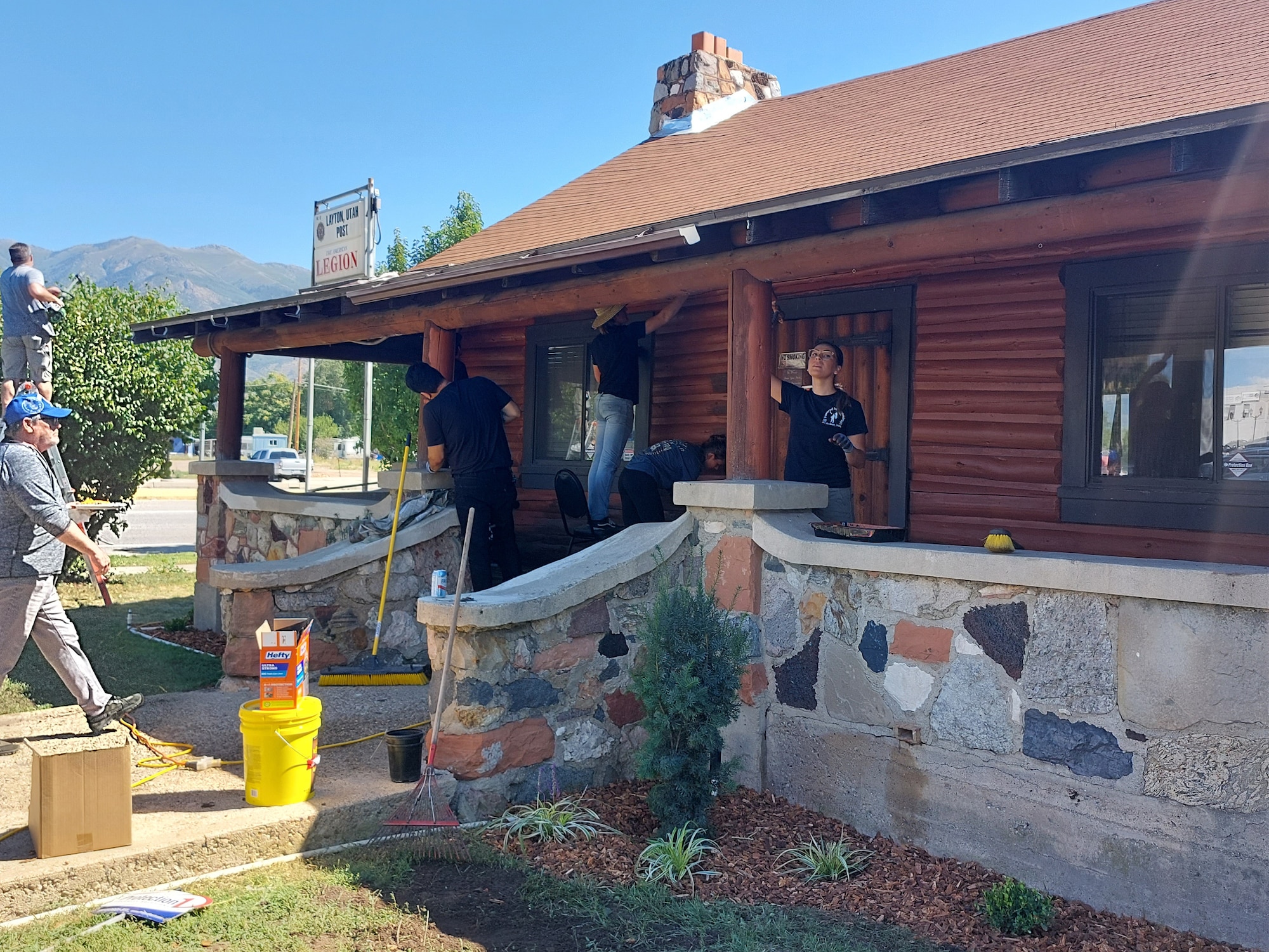 People working at a building that looks like a log cabin