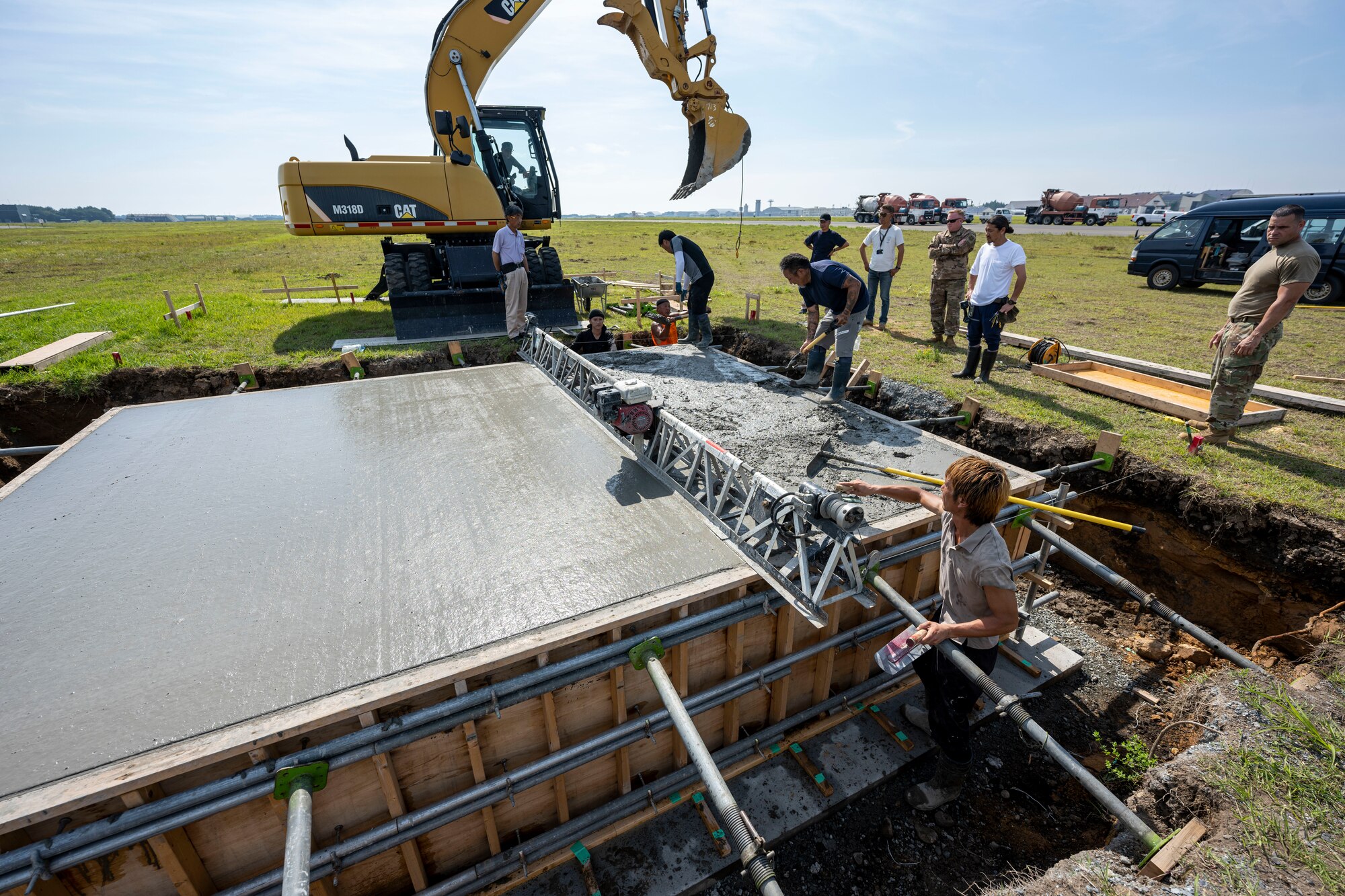 A group of people using a machines to smooth out wet concrete.