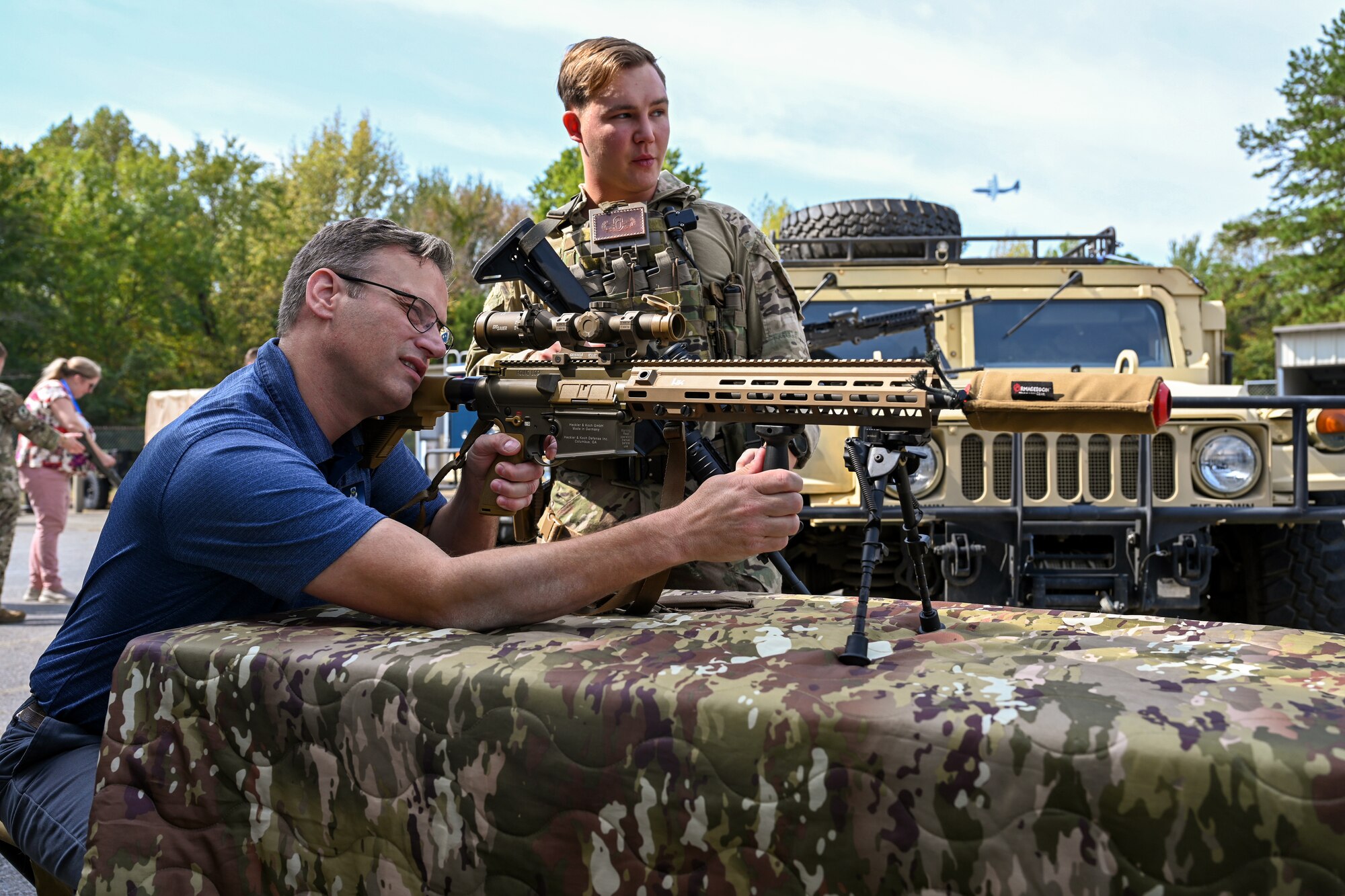 A Civic Leader adjusts the sights on a weapon.