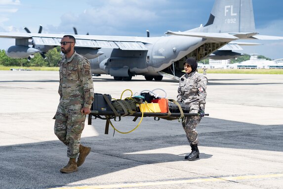 Photo of a U.S. Air Force Airman and Royal Brunei Air Force member transporting equipment