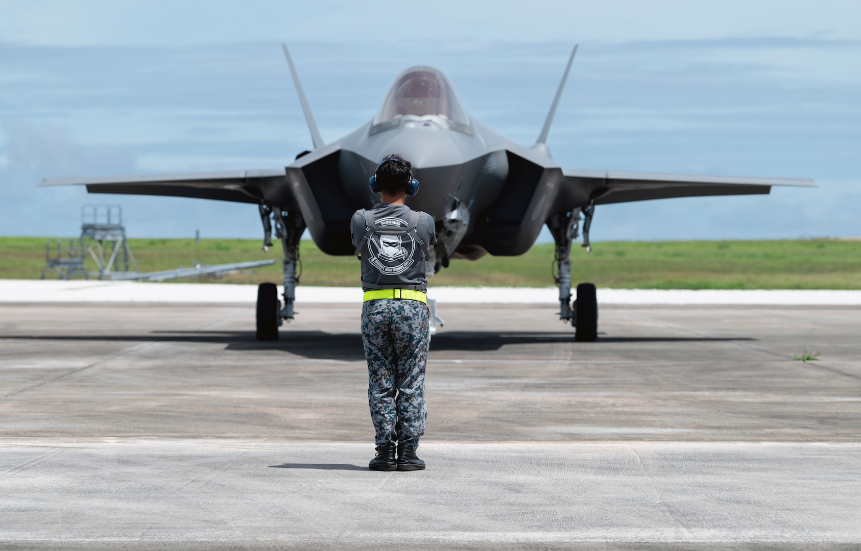 A Japan Air Self-Defense Force member marshals a F-35A Lightning II during a hot-pit refuel on Andersen Air Force Base, Guam, Aug. 28, 2023. This is Japan's first time taking a fifth generation platform outside their country. (U.S. Air Force photo by Airman 1st Class Lauren Clevenger)