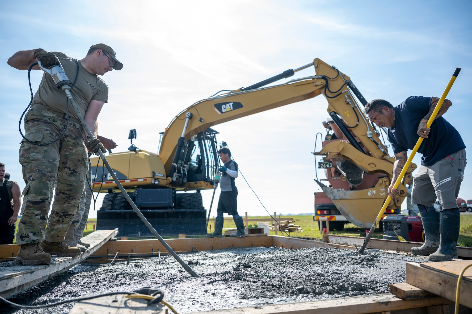 A group of people building a concrete pad