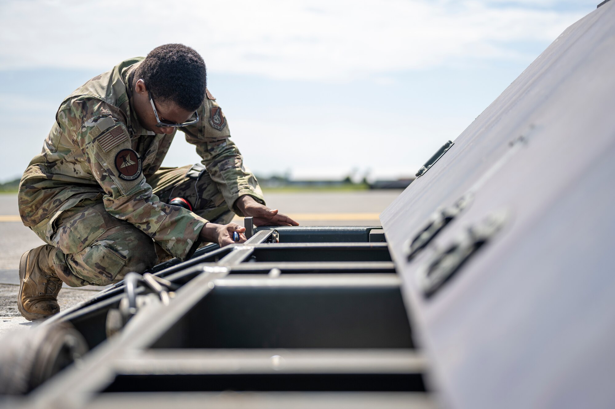 An airman removes a bolt.