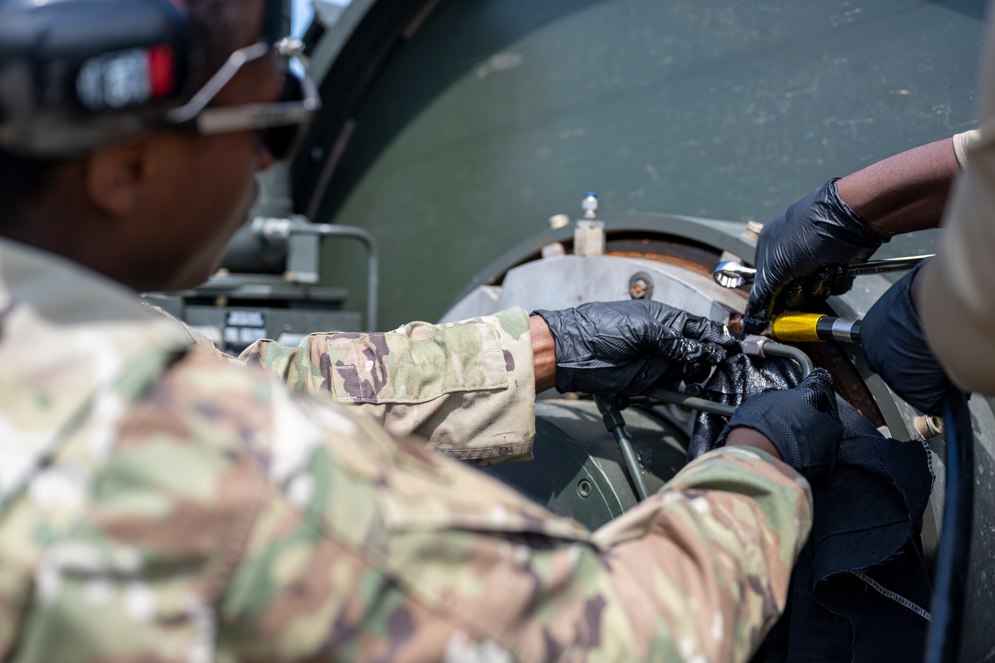 An Airman unplugs a brake fluid tube.