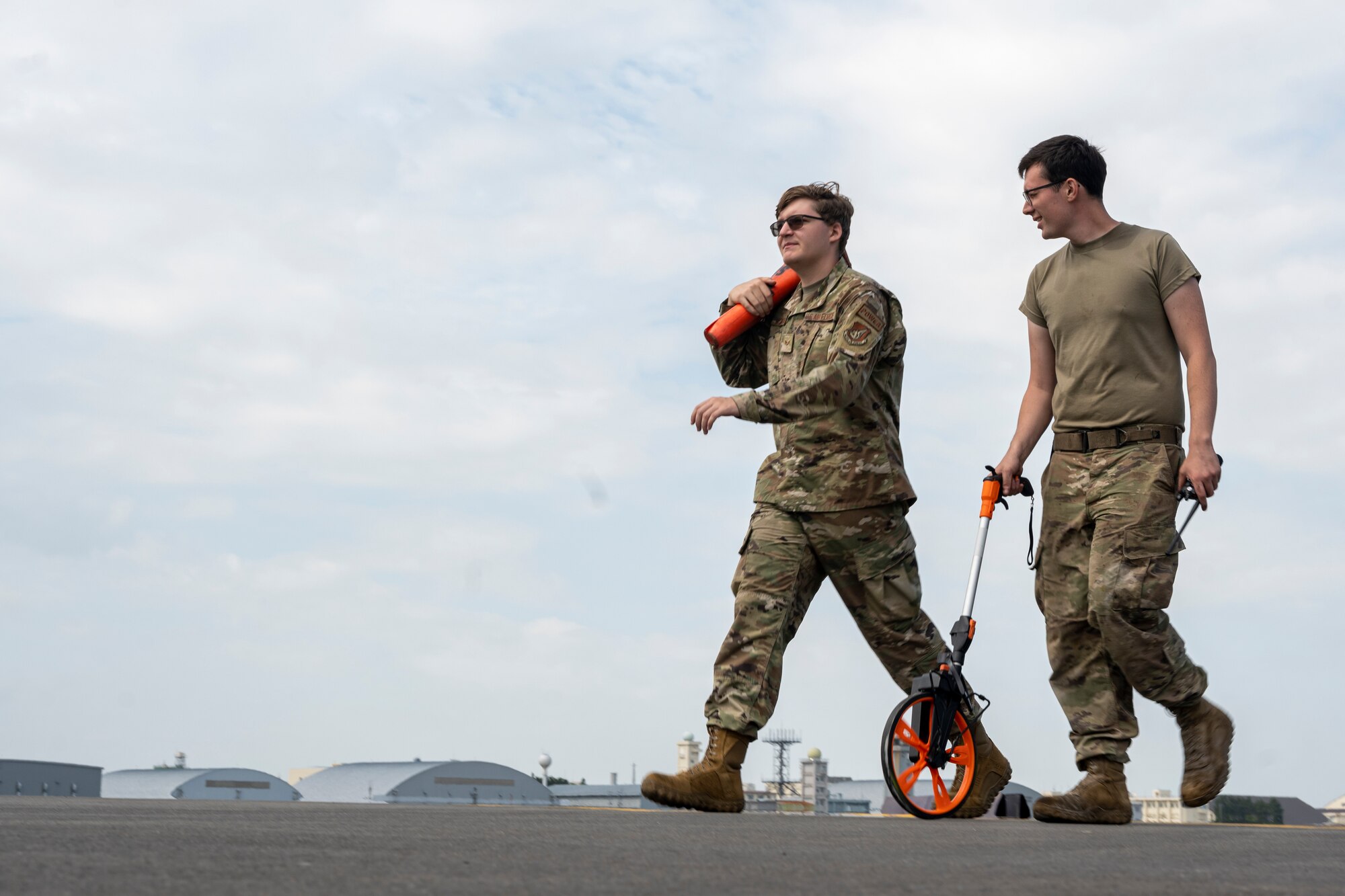 An Airman measure the distance as he walks down a runway.