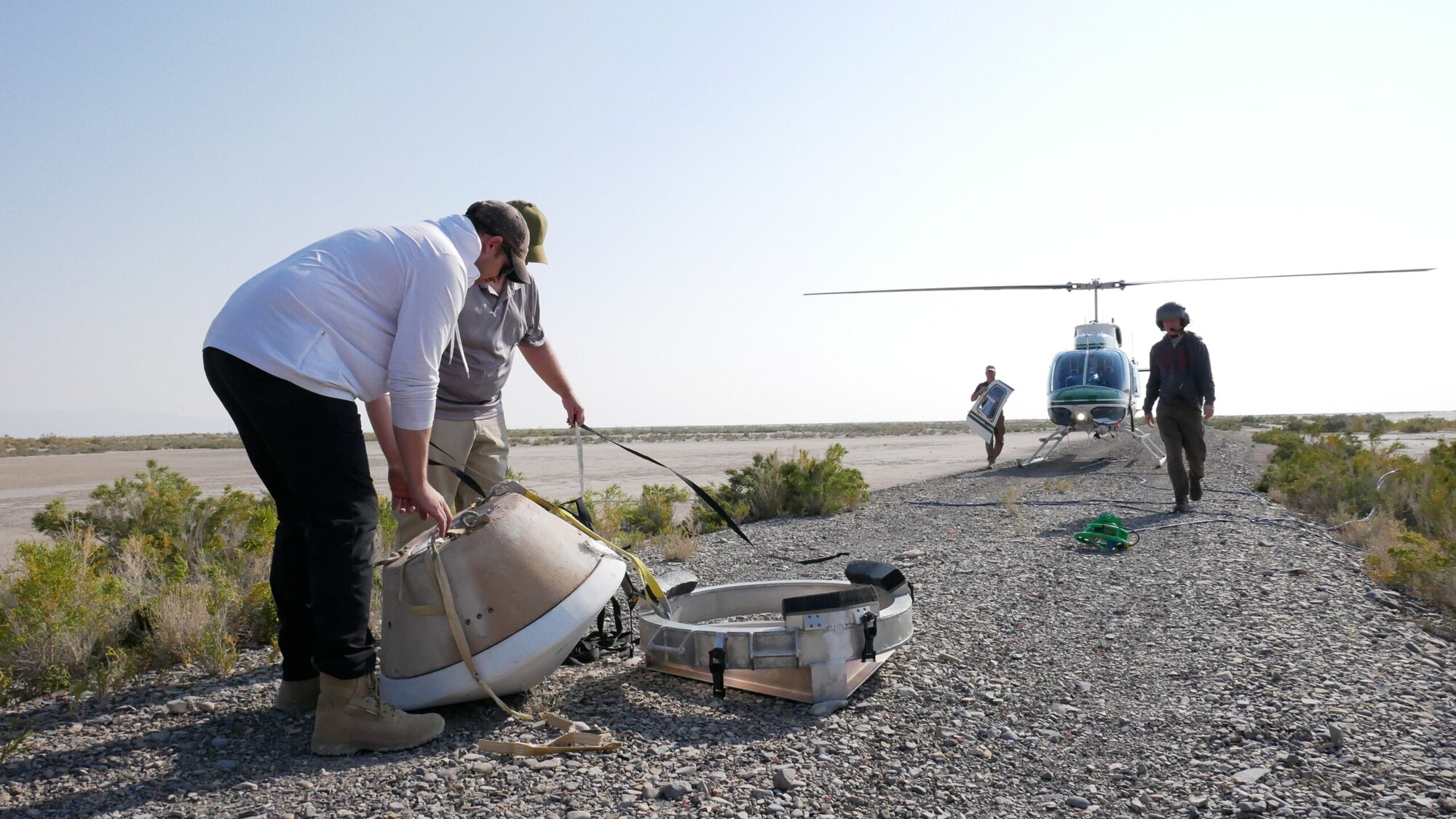 A photo of poeple packing up a large oval shaped capsule