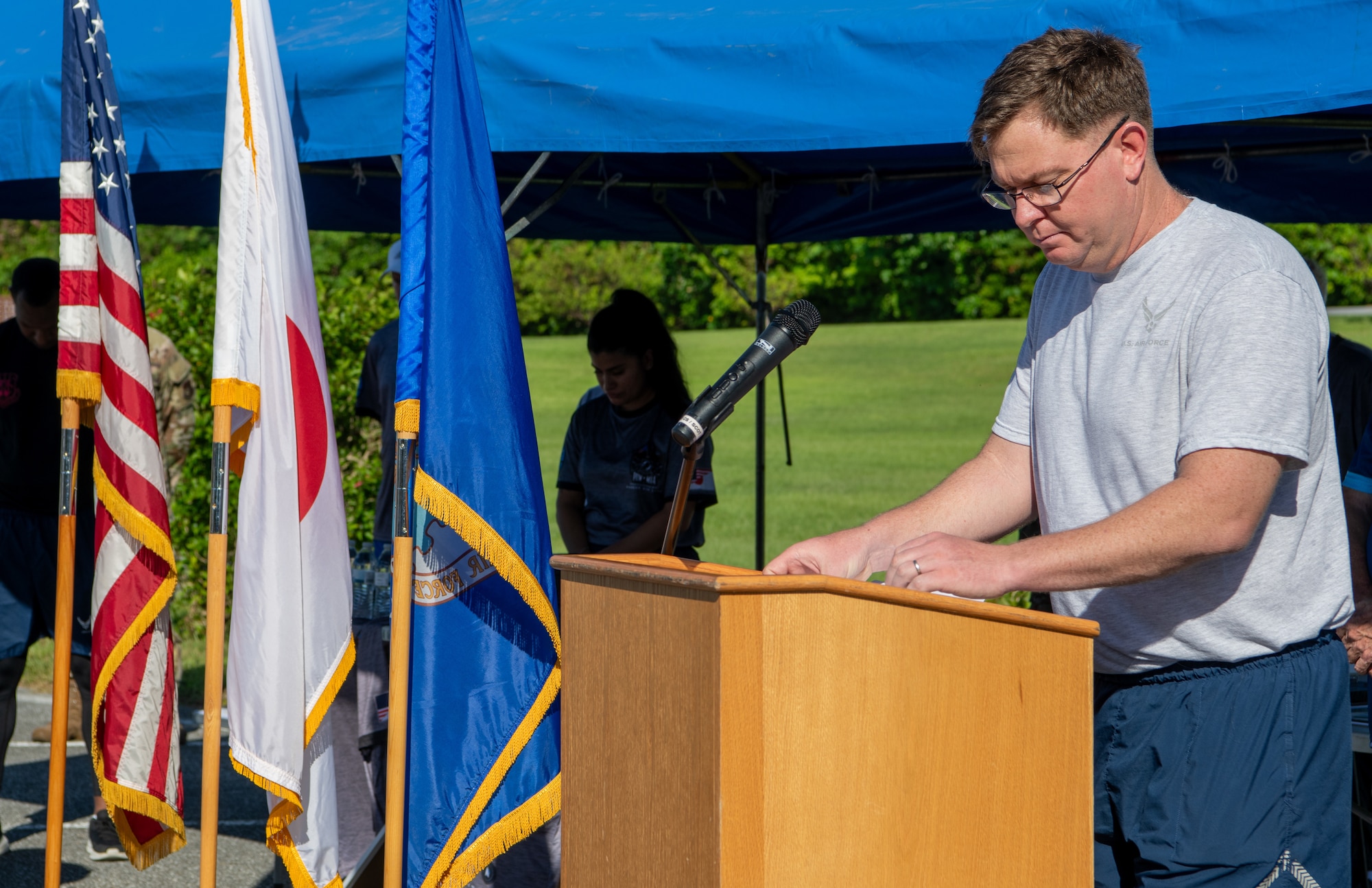 A chaplain leads a prayer at a podium.