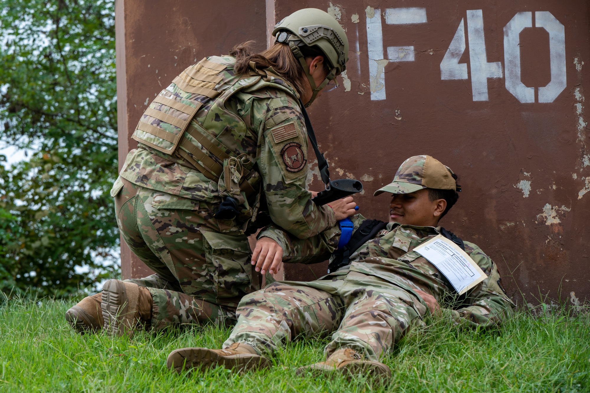 U.S. Air Force Airman Monserrath Becerra-Tellez, 51st Security Forces Squadron Defender, provides tactical combat casualty care to Airman 1st Class Favian Pimentel, 36th Fighter Generation Squadron weapons technician, during a simulated attack at Osan Air Base, Republic of Korea, Sept. 21, 2023. During contingencies, the 51st SFS augments Airmen throughout Osan to defend and deter adversarial threats. This defense strategy allows the base to maintain operational superiority by employing multi-capable Airmen. (U.S. Air Force photo by Airman 1st Class Chase Verzaal)