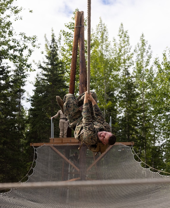U.S. Marine Corps Staff Sgt. Austin Martin, aircraft electric system technician, Intelligence support battalion, Marine Forces Reserve, slides down an obstacle during the confidence course for the 4th Marine Division Super Squad Competition at Joint Base Elmendorf-Richardson, Alaska, July, 21, 2023. During the multi-day competition, Reserve units from all across the Marine Corps, exercised their technical and tactical proficiencies by competing in events that highlighted offensive/defensive operations, patrolling techniques, combat marksmanship, physical endurance and small unit leadership. (U.S. Marine Corps photo by Cpl. Mitchell Johnson)