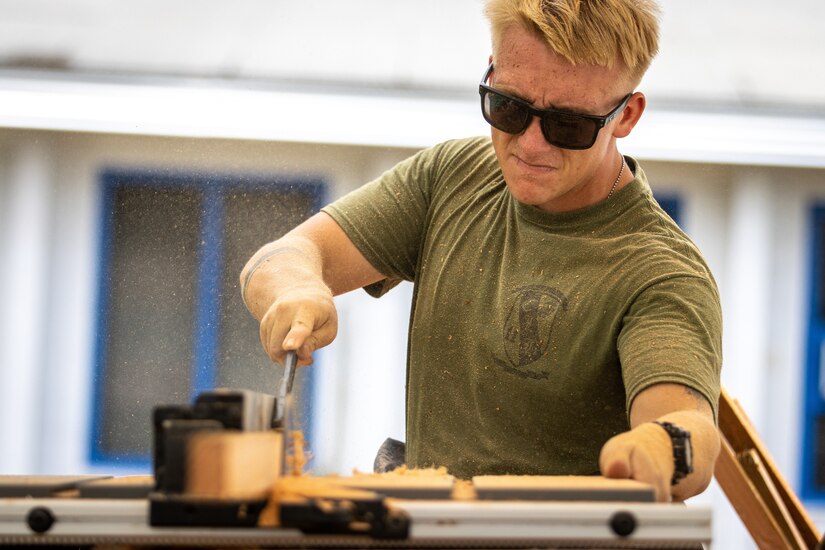 A Marine uses a saw.