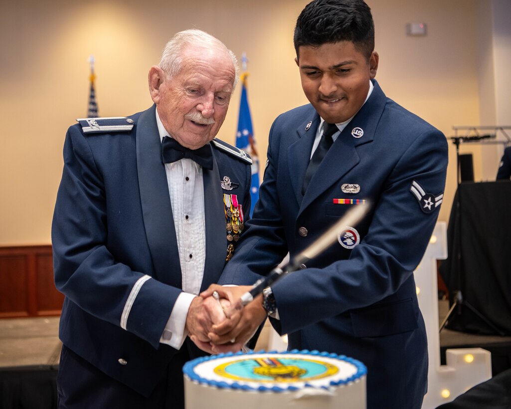 Retired Col. Len Augustine and Airman 1st Class Jayden Chetram, 60th Communications Squadron network and infrastructure technician, cut the cake