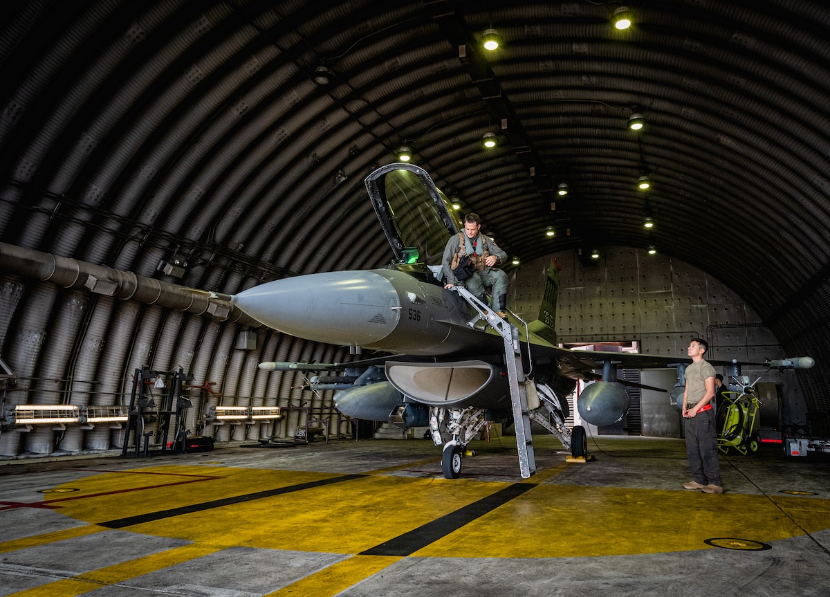 U.S. Air Force Lt. Col. Corey Farrer, 36th Fighter Squadron pilot, climbs into the cockpit of a F-16 Fighting Falcon