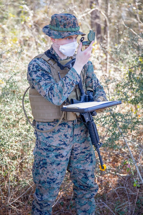 Lance Cpl. Daniel Hance, an intelligence specialist for Battlespace Surveillance Company, shoots an azimuth during a reconnaissance and surveillance field exercise aboard Camp Shelby, Miss., Feb. 19, 2021. This training develops and refines platoon and section patrolling and increases proficiency in ground sensor operations. (U.S. Marine Corps photo by Lance Cpl. Mitchell Collyer)